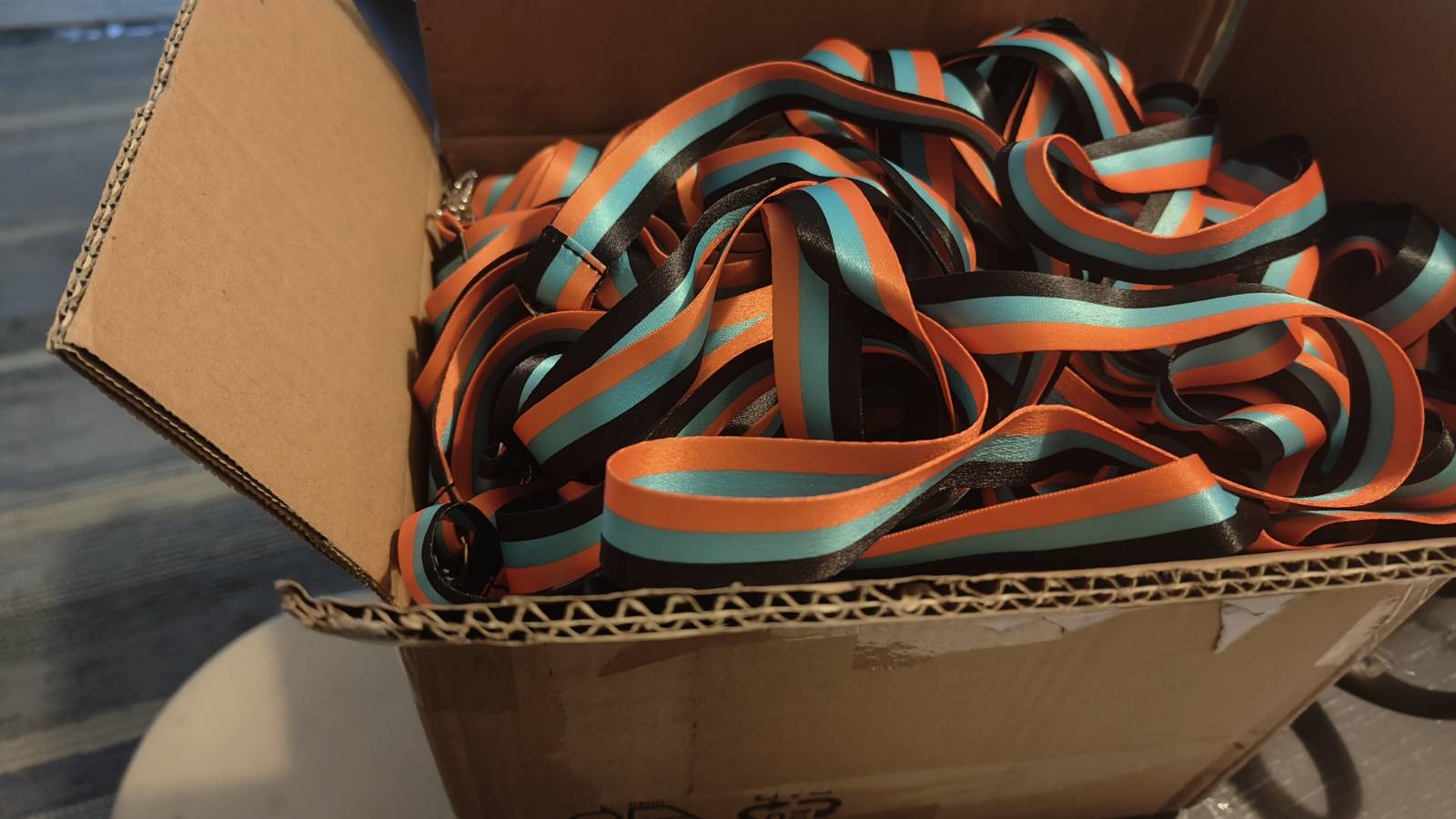 The Tricolor of Collapse flag with horizontal orange, teal, and black fields on a light gray background.